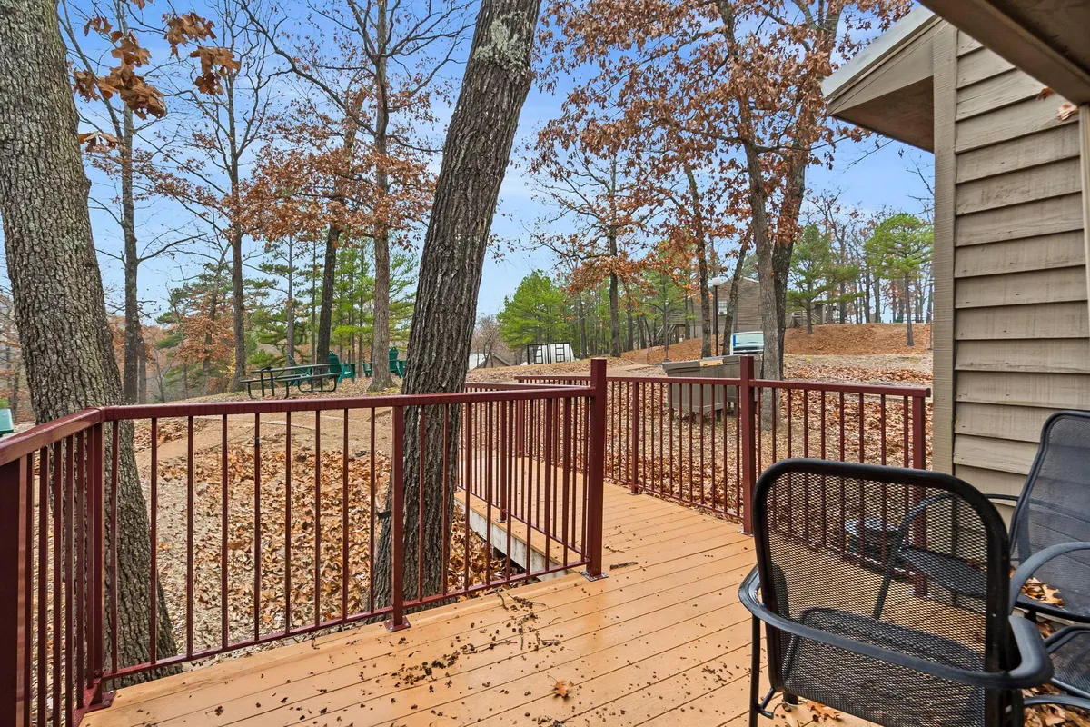 A peaceful wooden deck surrounded by tall trees and overlooking an expansive outdoor area, perfect for relaxing while immersed in nature. The setting is ideal for taking in the forested atmosphere and offers plenty of space for you and your dog to enjoy the outdoors together.